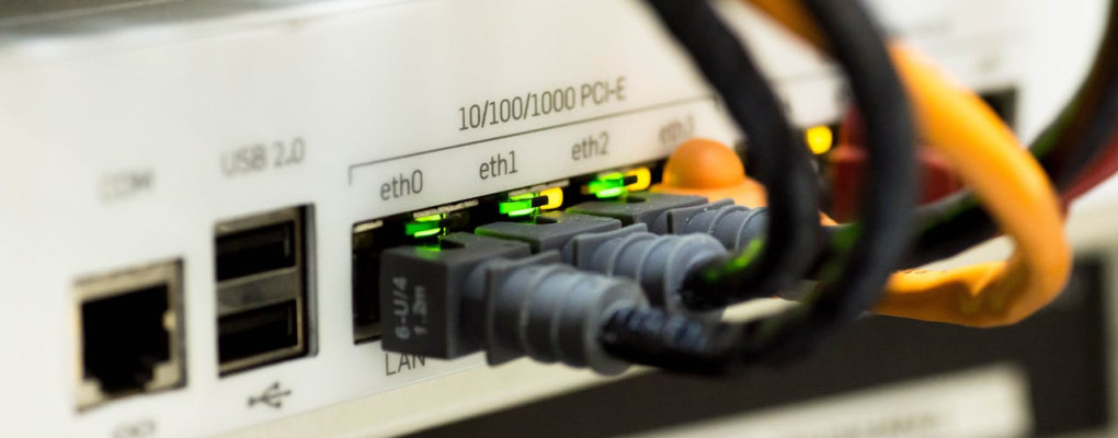 Detailed close-up of ethernet cables and network connections on a router, showcasing modern technology.